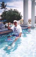 A pool, a drink, sunny sky, warm weather and a very happy man.